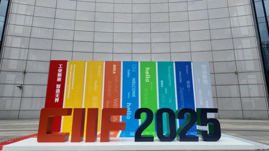 Colorful “CIIF 2025” sculpture on a white base, surrounded by vibrant banners reading “WELCOME” and global exhibition themes.